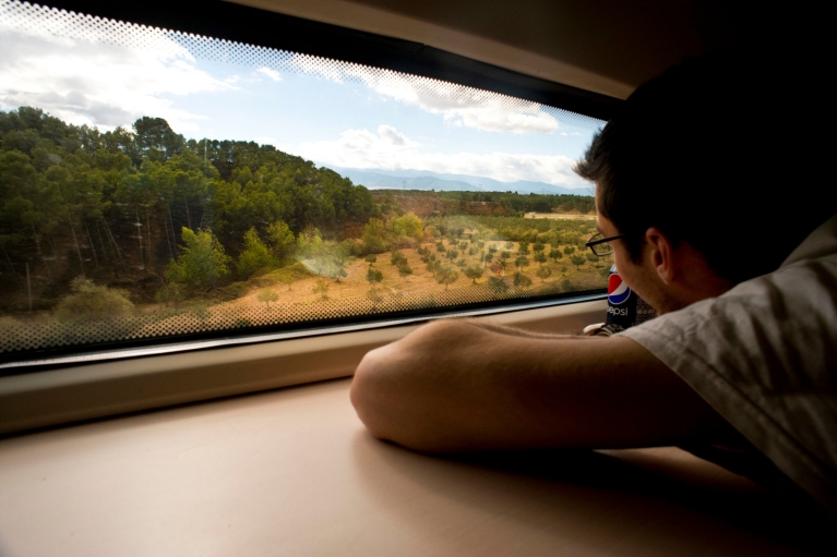 Homem admirando a paisagem panorâmica da janela do trem AVE, Almeria – Granada, Espanha